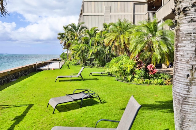 view of home's community with a lawn and a water view