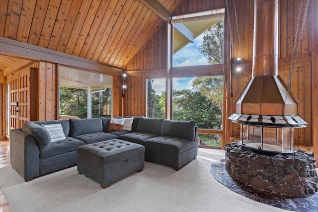 sunroom featuring lofted ceiling, plenty of natural light, wooden ceiling, and a wood stove