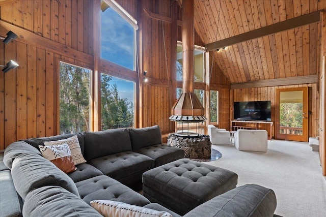 carpeted living room with wooden walls, high vaulted ceiling, beam ceiling, and wooden ceiling