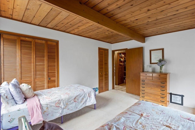 carpeted bedroom with two closets, wooden ceiling, and beam ceiling