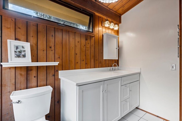 bathroom with vanity, toilet, and wood walls