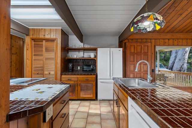 kitchen with sink, tile counters, beamed ceiling, white appliances, and white cabinets