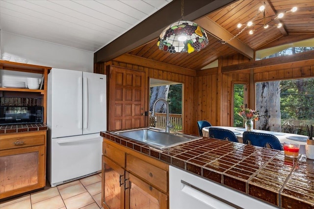 kitchen featuring lofted ceiling with beams, sink, light tile patterned floors, wooden ceiling, and white appliances