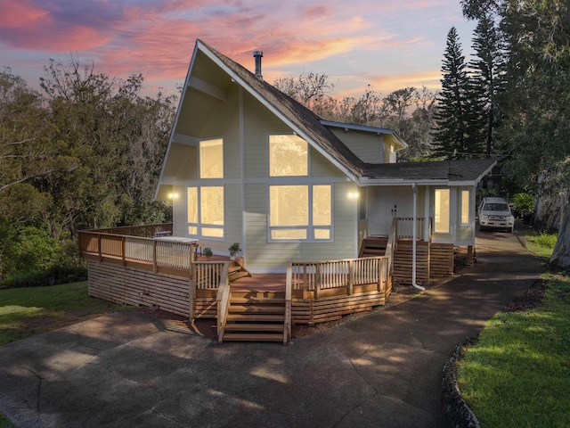 back house at dusk featuring a deck