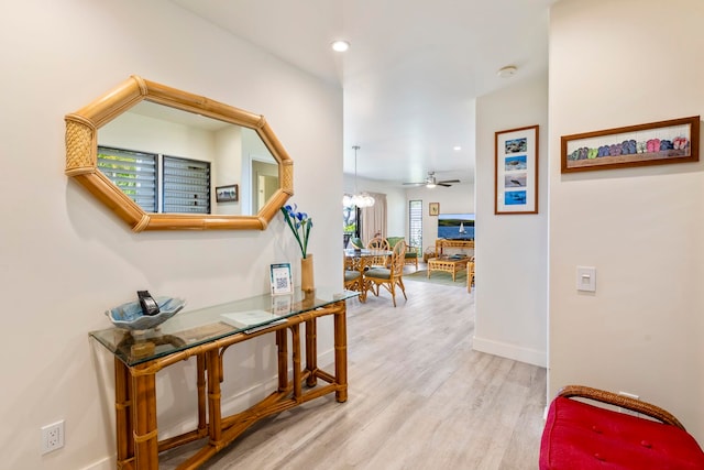 hallway with a notable chandelier and light hardwood / wood-style flooring