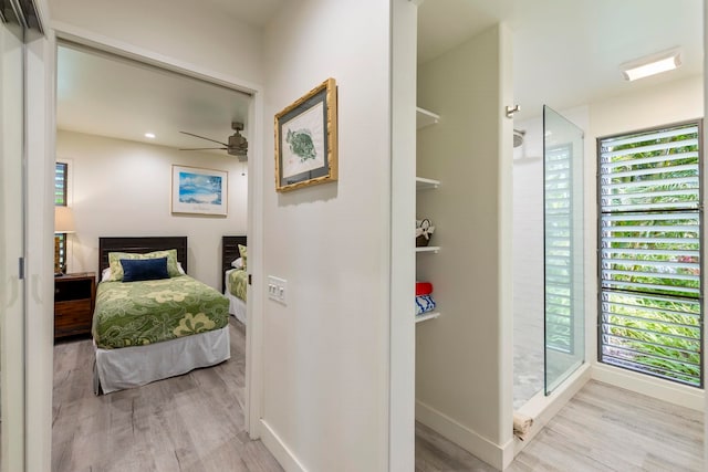 bedroom featuring light hardwood / wood-style flooring, multiple windows, and ceiling fan