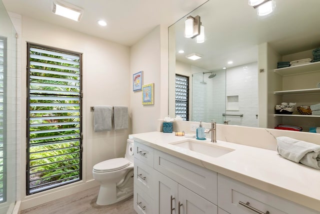 bathroom featuring tiled shower, a wealth of natural light, vanity, and hardwood / wood-style flooring