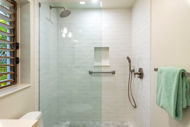 bathroom featuring toilet and tiled shower