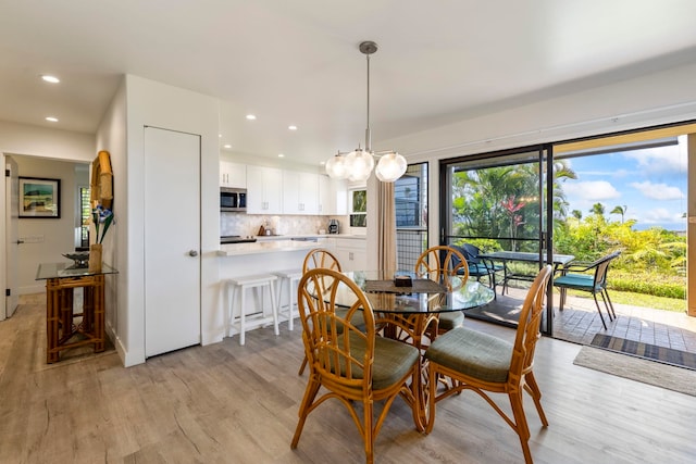 dining area with an inviting chandelier and light hardwood / wood-style flooring