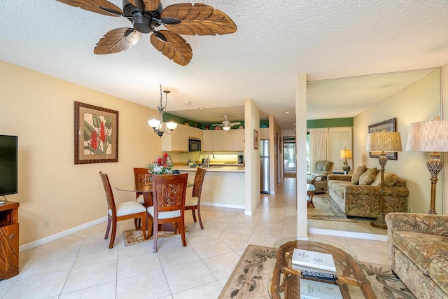 dining room featuring sink, a textured ceiling, ceiling fan with notable chandelier, and light tile patterned flooring