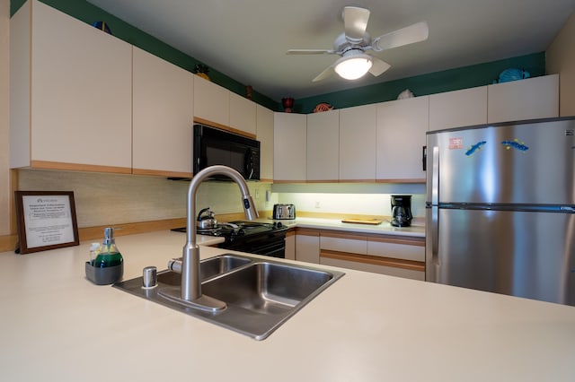 kitchen featuring white cabinets, sink, ceiling fan, and black appliances