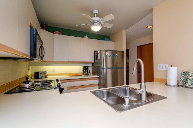 kitchen featuring white cabinetry, stainless steel fridge, sink, and a textured ceiling