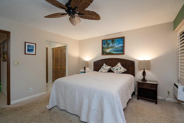 bedroom with ceiling fan, a closet, light colored carpet, and a textured ceiling