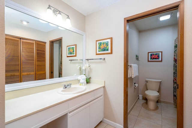 bathroom featuring tile patterned flooring, vanity, and toilet