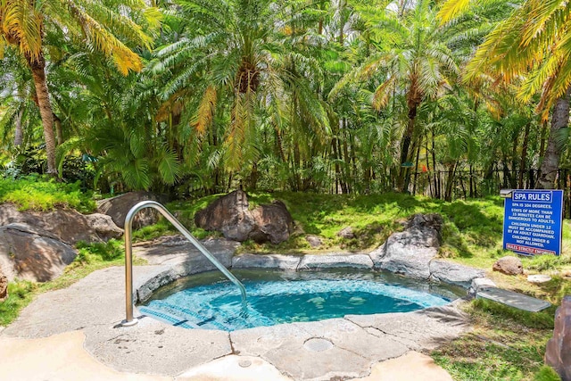 view of swimming pool with a hot tub