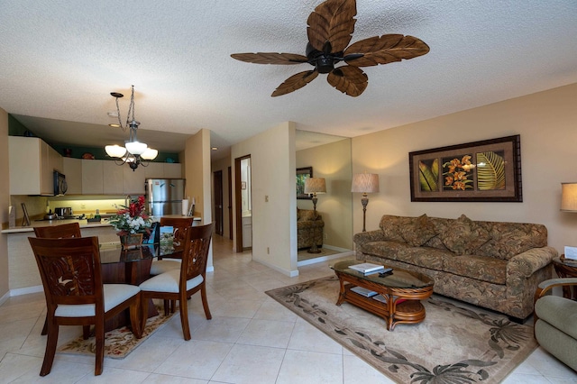 tiled living room featuring ceiling fan with notable chandelier and a textured ceiling