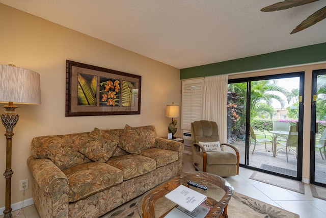 living room featuring light tile patterned floors, a textured ceiling, and ceiling fan