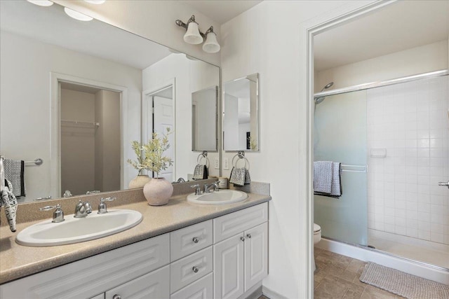 bathroom featuring toilet, an enclosed shower, and vanity