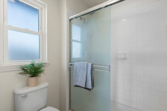 bathroom with toilet and a shower with shower door