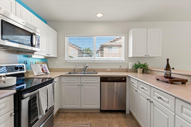 kitchen with white cabinets, appliances with stainless steel finishes, and sink