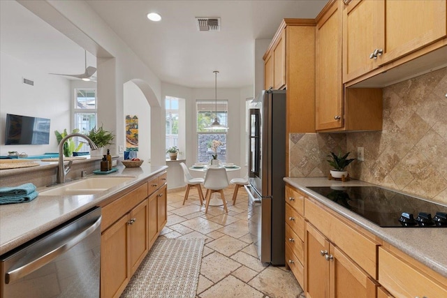 kitchen with decorative light fixtures, tasteful backsplash, sink, and stainless steel appliances