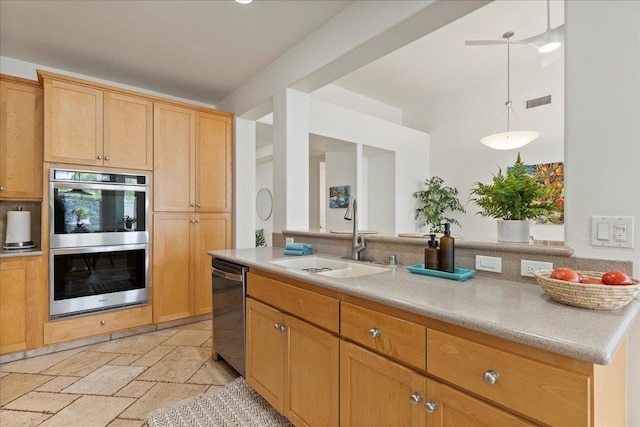 kitchen with light brown cabinetry, sink, hanging light fixtures, and appliances with stainless steel finishes