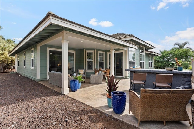 back of property featuring a patio area and an outdoor living space