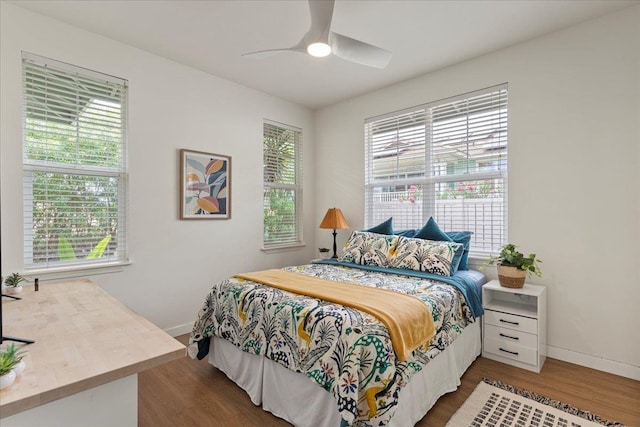 bedroom with dark hardwood / wood-style floors and ceiling fan