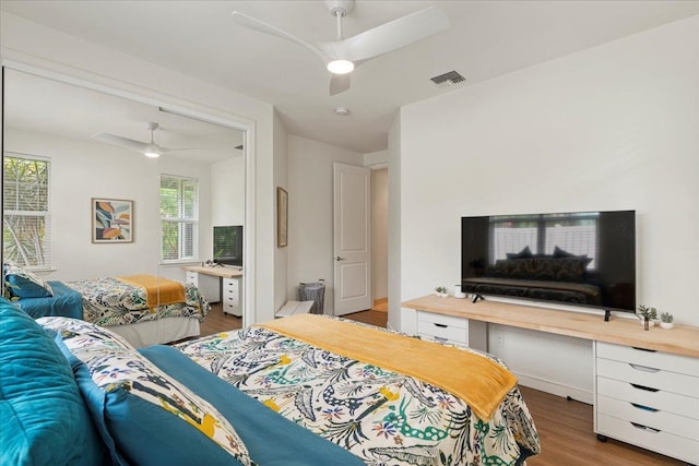 bedroom featuring multiple windows, ceiling fan, and hardwood / wood-style floors