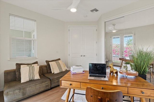 home office with ceiling fan and light wood-type flooring