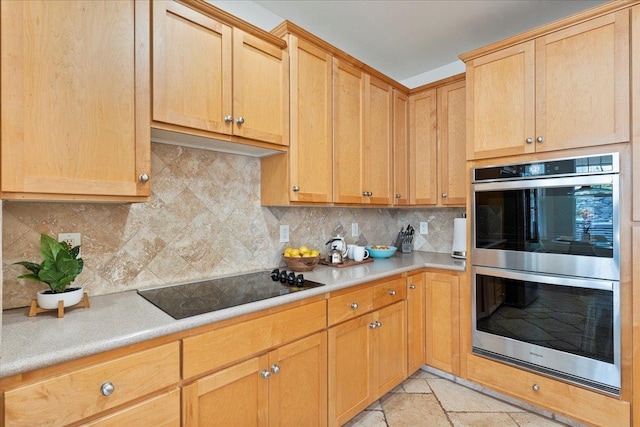 kitchen featuring double oven, black electric cooktop, backsplash, and light brown cabinetry