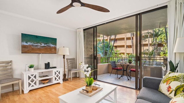 living room with hardwood / wood-style flooring, ceiling fan, ornamental molding, and plenty of natural light