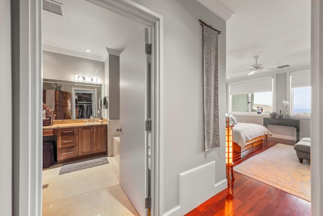 bathroom featuring hardwood / wood-style floors, ceiling fan, ornamental molding, and vanity