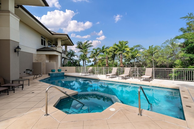 view of swimming pool featuring an in ground hot tub and a patio