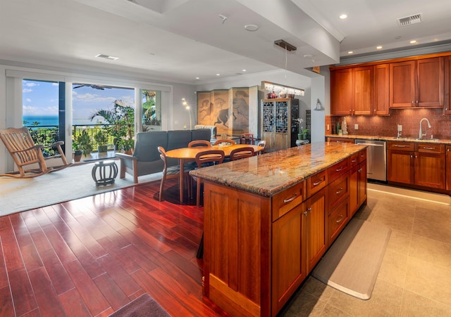 kitchen with tasteful backsplash, decorative light fixtures, dishwasher, light hardwood / wood-style floors, and a kitchen island