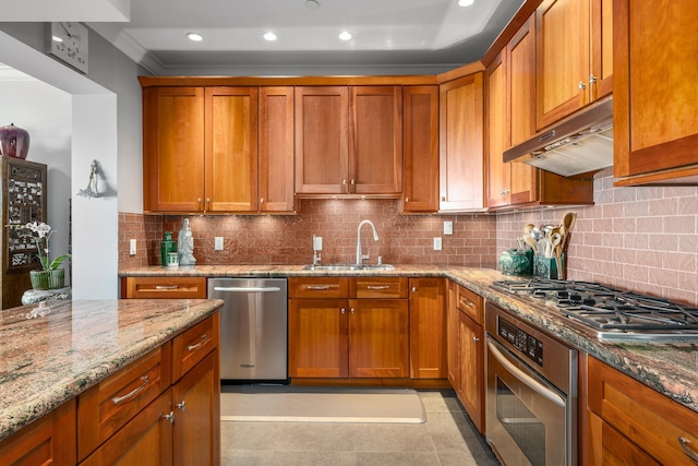 kitchen with backsplash, sink, light stone countertops, appliances with stainless steel finishes, and light tile patterned flooring