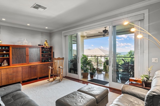 living room with ceiling fan, wood-type flooring, and ornamental molding