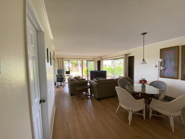 50 Kepuhi Pl Unit 117, Maunaloa, HI 96770 - dining area with a textured ceiling, ornamental molding, and light wood finished floors