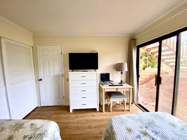 50 Kepuhi Pl Unit 117, Maunaloa, HI 96770 - bedroom with a textured ceiling, light wood-type flooring, ornamental molding, and access to outside