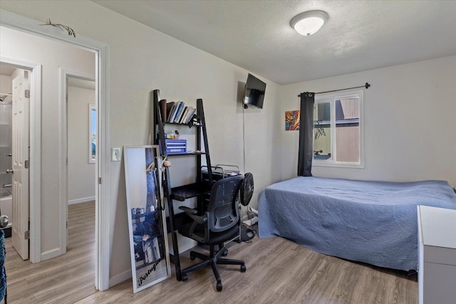 bedroom featuring a textured ceiling and light wood-type flooring