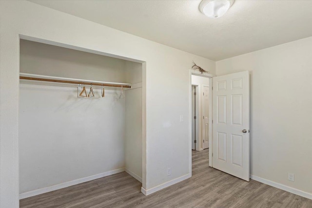 unfurnished bedroom with hardwood / wood-style flooring and a closet