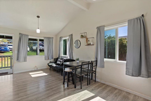 dining area featuring hardwood / wood-style floors and vaulted ceiling with beams