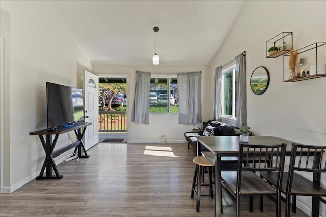 dining room with vaulted ceiling and hardwood / wood-style floors