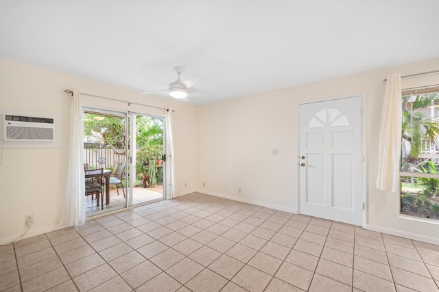 spare room with a wall unit AC, a ceiling fan, plenty of natural light, and light tile patterned floors