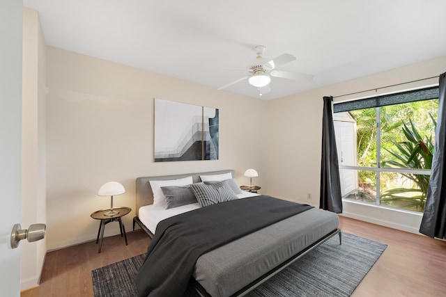 bedroom featuring wood finished floors, ceiling fan, and baseboards