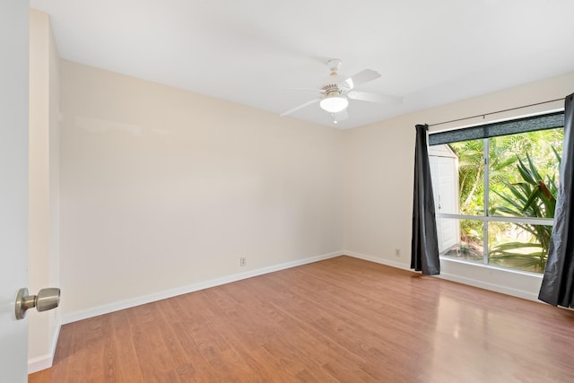 spare room with light wood-style flooring, baseboards, and a ceiling fan