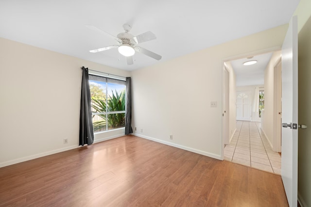 unfurnished room featuring light wood-style flooring, a ceiling fan, and baseboards