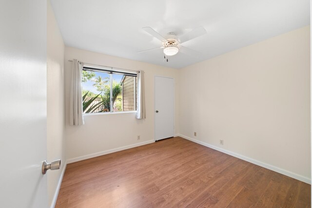empty room featuring wood finished floors and baseboards