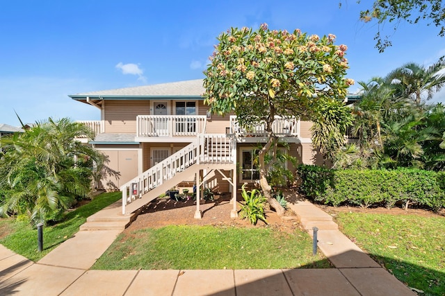 view of front facade featuring stairway, a porch, and a front lawn