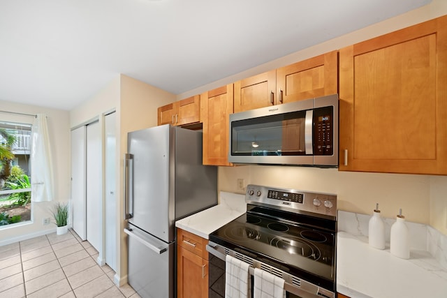 kitchen featuring stainless steel appliances, light countertops, and light tile patterned floors
